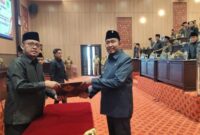 Bupati Fauzi (kanan) saat menerima salinan persetujuan raperda pertanggungjawaban APBD 2025