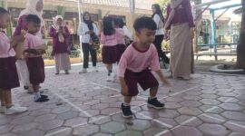 Seorang anak TK yang sedang mencoba permainan Engklek