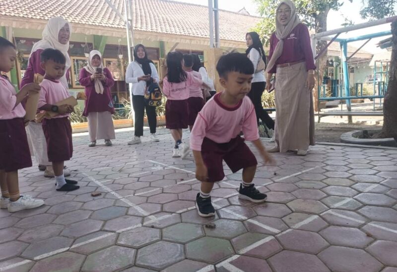 Seorang anak TK yang sedang mencoba permainan Engklek