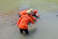 Tim dari Basarnas saat evakuasi korban dari dasar sungai