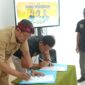 Ketua PWI Pamekasan, Hairul Anam menandatangani MoU bersama Kepala Dinas Perpustakaan dan Arsip M. Tabrani Pamekasan, Munapik di Aula lantai 2 Perpusda, Selasa (15/09/2026) dalam rangkaian acara hari Kunjung Perpustakaan Nasional