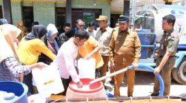 Bupati Sumenep Dr Achmad Fauzi Wongsojudo mengisi langsung tempat air warga dibantu Ketua Baznas Sumenep Ahmad Rahman (berkaos putih)